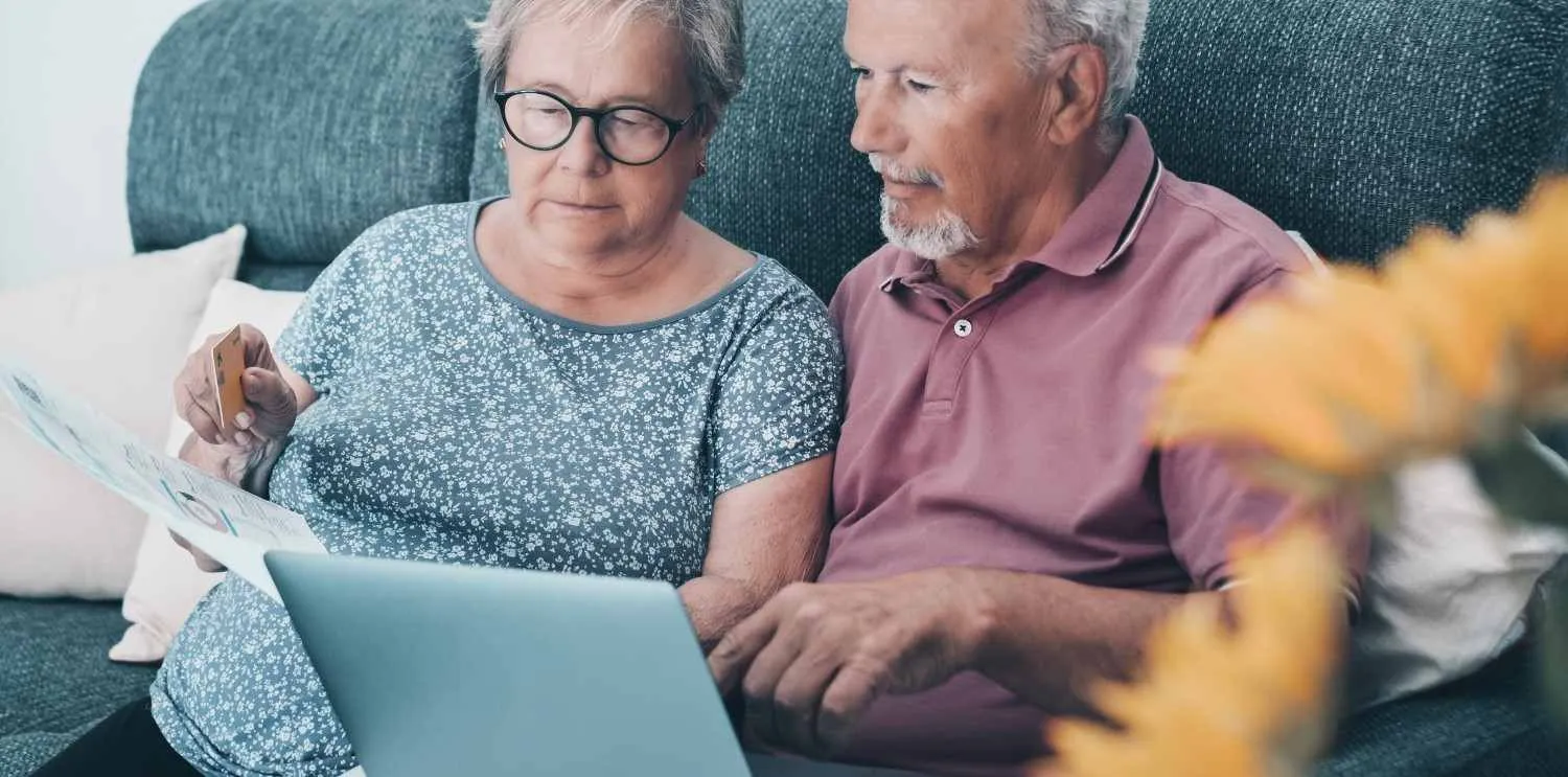 Older couple going over papers together on the sofa